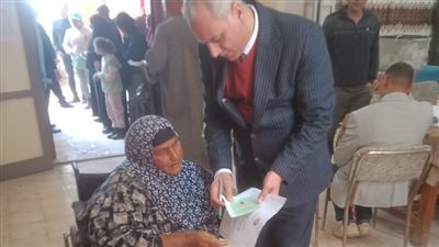 مستشار يساعد مسنة قعيدة للإدلاء بصوتها فى انتخابات النواب بكفر الشيخ 